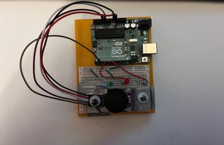 A game controller made with an arduino uno, wearing googly eyes.